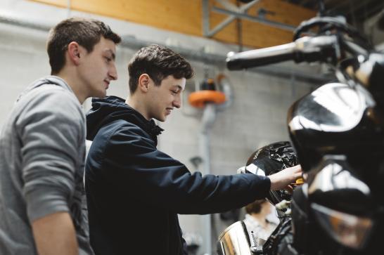 Deux jeunes mécaniciens inspectant une moto
