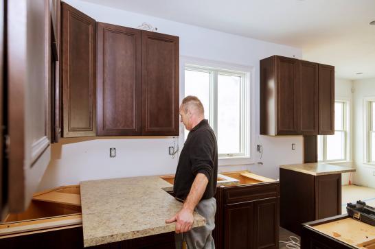 Homme qui place un plan de travail dans une cuisine