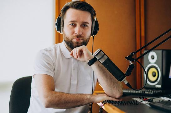 Animateur radio derrière son micro dans un studio