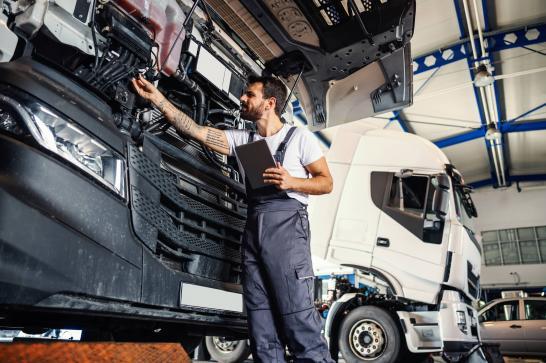 Mécanicien poids lourds en train de vérifier la durite d'un moteur de camion