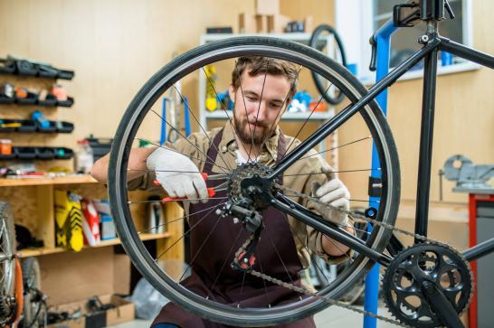 Mécanicien en train de réparer une roue de vélo sur un établi