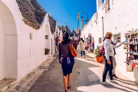 Guide touristique dans une petite rue qui porte son parapluie fermé en l'air afin d'être aperçue par le reste du groupe