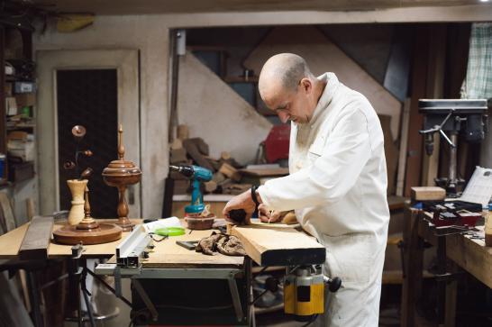 Ebéniste dans son atelier en train de travailler une pièce de bois