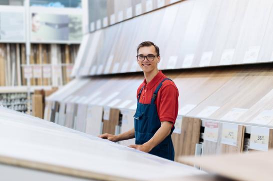 Vendeur dans un magasin de bricolage. On voit un vendeur au milieu d'un rayon de parquet