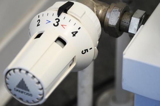 Vanne thermostatique blanche qui laisse deviner un radiateur
