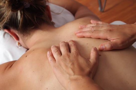 Mains d'homme faisant un massage dorsal à une femme