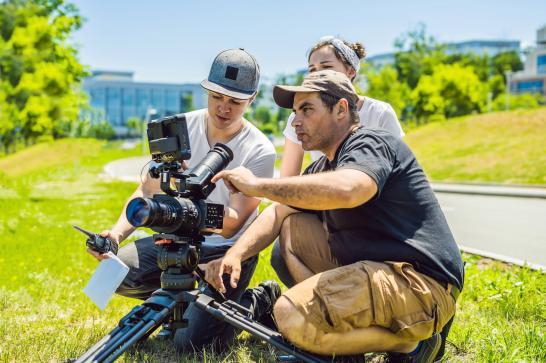 Régisseur audiovisuel qui donne ses instructions au caméraman en place sur un lieu de tournage
