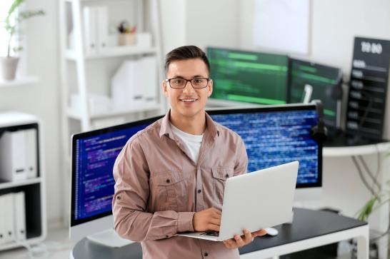 Développeur d'application mobile dans son bureau avec un ordinateur en main