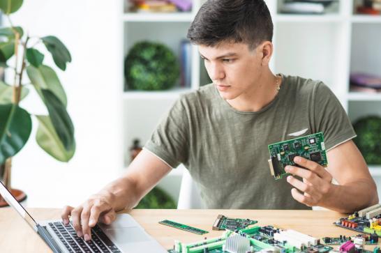 Jeune garçon qui tient des composants informatiques dans ses mains