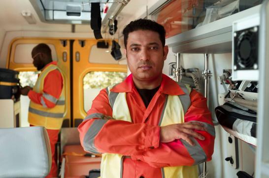 Ambulancier de transport non urgent en tenue de travail, dans son ambulance