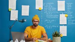 homme assis à un bureau avec un bonnet