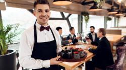 Serveur de restaurant en train d'apporter un plateau de thé à des clients dans un resturant